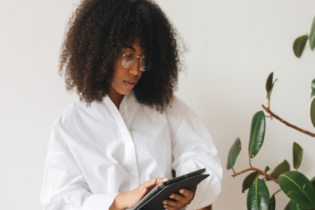 Person with medium-dark skin tone looks at their tablet.